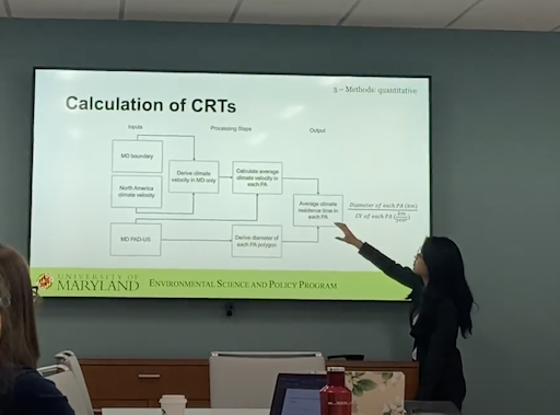  Marie posing in front of her oral defense slides, and presenting the algorithm she developed to calculate the climate residence time in each protected area.