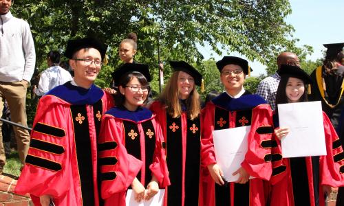 PhD students in regalia with their degrees
