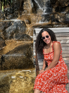 Kristen Halliday sits on a bench next to a waterfall.
