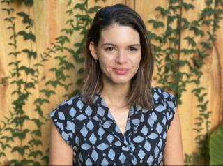 Photo of Ms Devereux against a backdrop with green vines